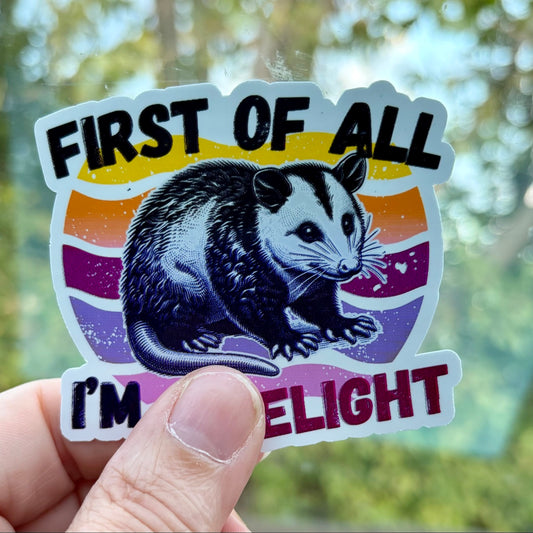 First of All I'm a Delight opossum sticker held in hand outdoors